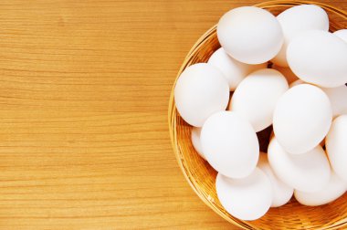 ahşap masa üzerinde birçok beyaz yumurta