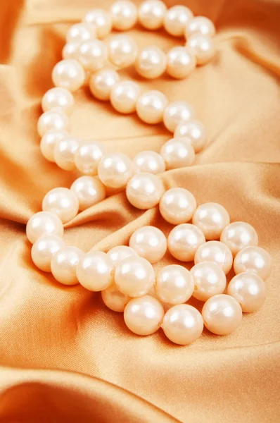 Collar de perlas en el fondo satinado brillante —  Fotos de Stock