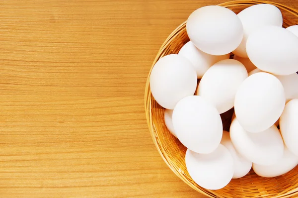A fából készült asztal sok fehér tojás — Stock Fotó