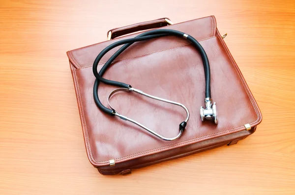 Doktorsväska med stetoskop mot trä bakgrund — Stockfoto