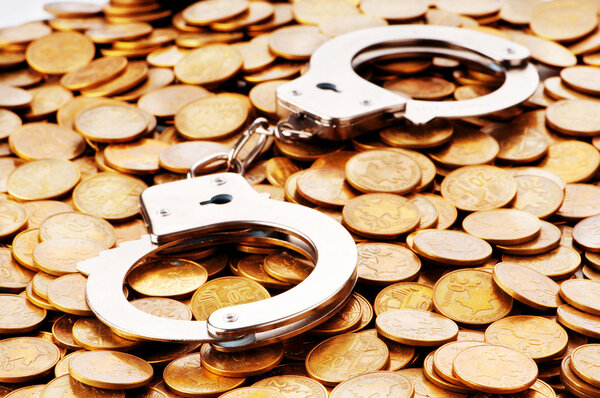 Hand cuffs and coins as security concept
