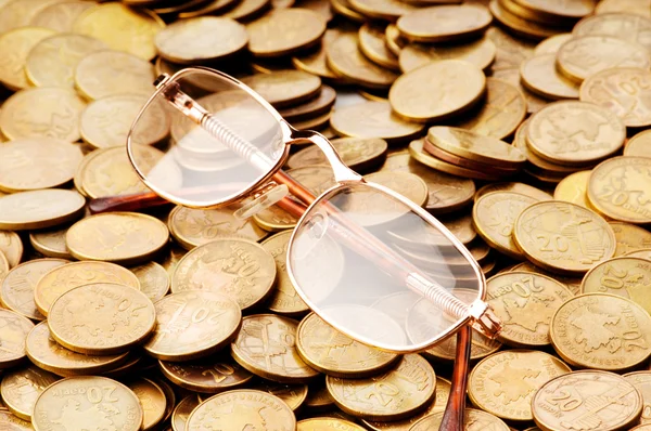 stock image Many coins and reading glasses as business concept