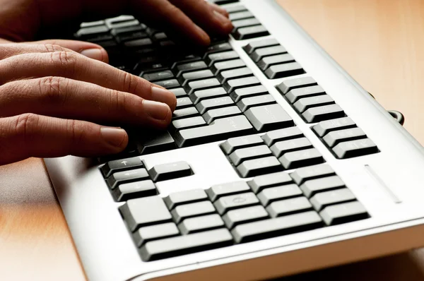 Two hands working on the silver keyboard — Stock Photo, Image