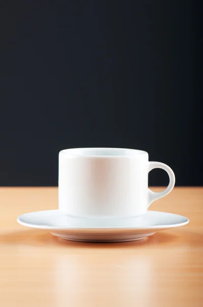 Bílý pohár proti barevným přechodem na stůl — Stock fotografie