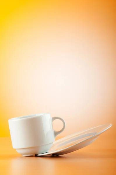 Copa blanca contra gradiente de colores en la mesa — Foto de Stock