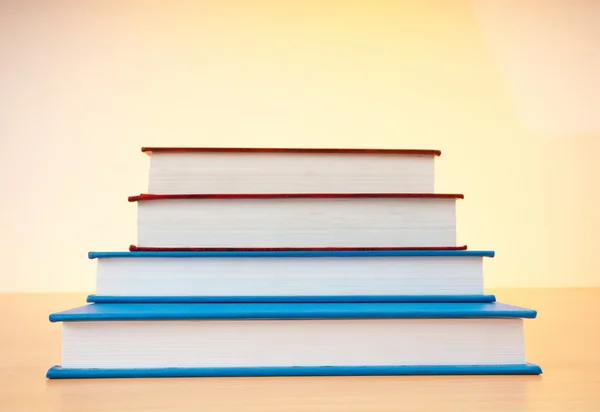 Stack of text books against gradient background — Stock Photo, Image