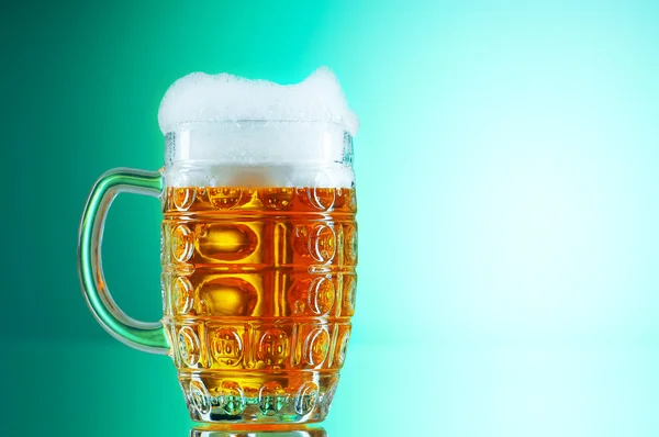 カラフルなグラデーションの背景に対してビールグラス — ストック写真