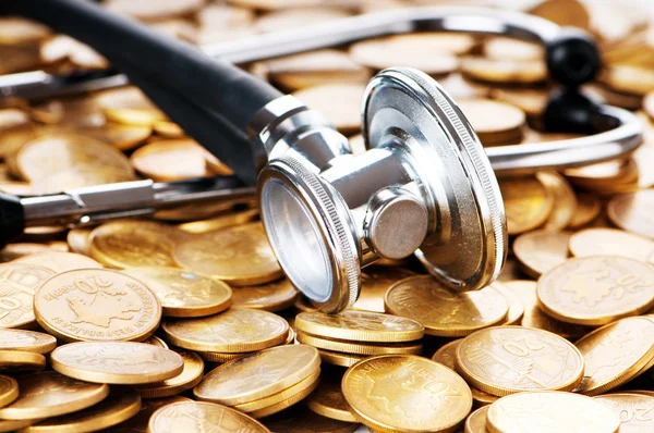 Concept of expensive healthcare with coins and stethoscope — Stock Photo, Image
