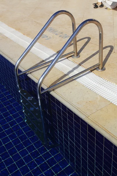 stock image Fragment of swimming pool with a ladder and transparent water