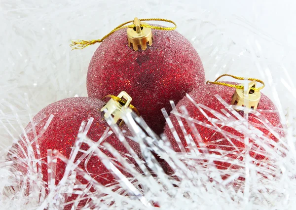Three red Christmas ball in tinsel — Stock Photo, Image
