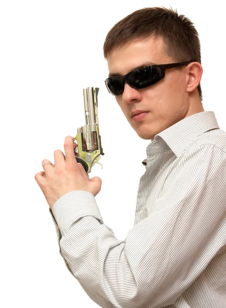 A guy with a gun in his hand wearing sunglasses on a white backg — Stock Photo, Image