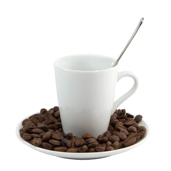 Chicchi di caffè in una tazza bianca e disseminato su una caffettiera — Foto Stock