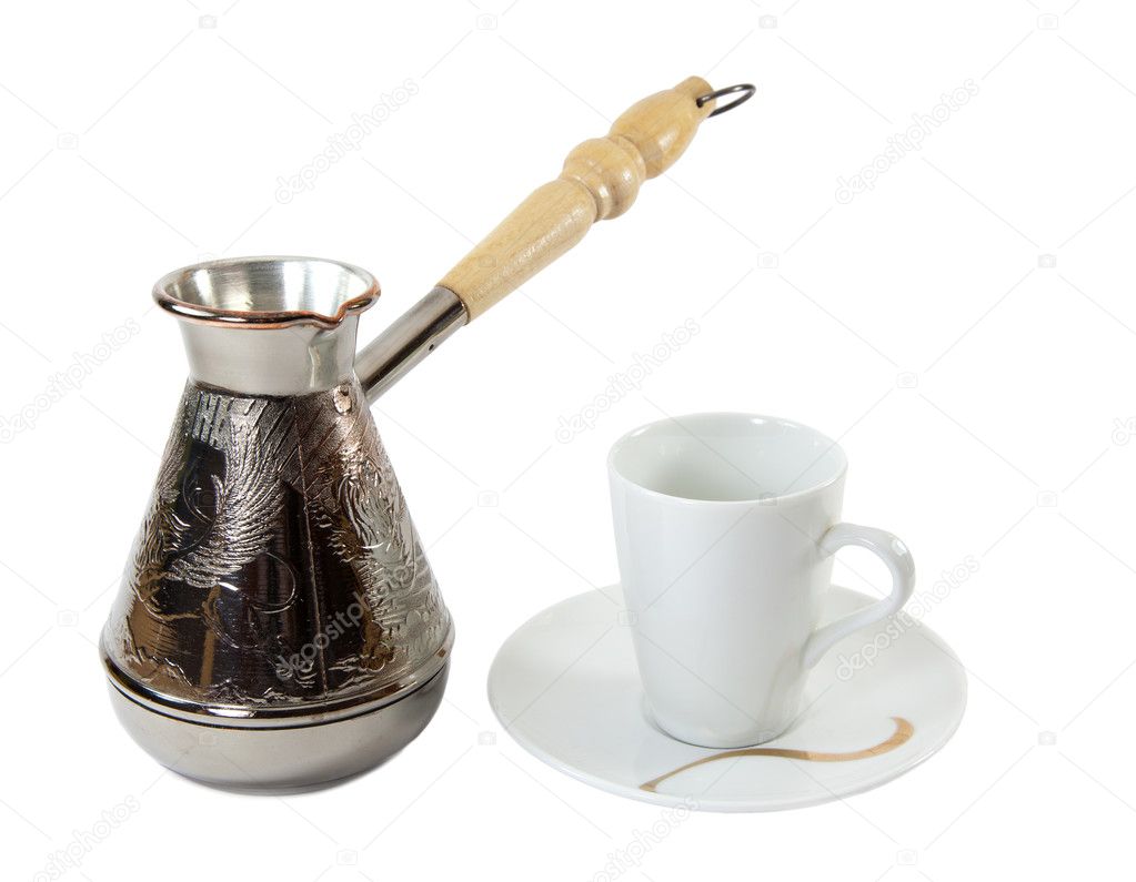 Coffee grains in a white cup and disseminated about a coffee pot