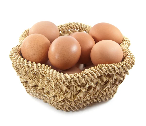 在白色背景上的棕色篮子中的复活节彩蛋 — 图库照片
