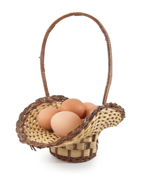 在白色背景上的棕色篮子中的复活节彩蛋 — 图库照片
