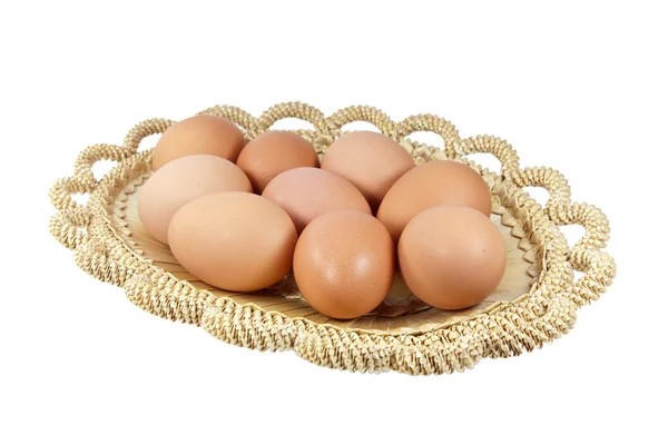 Ovos de Páscoa em cesta marrom em um fundo branco — Fotografia de Stock
