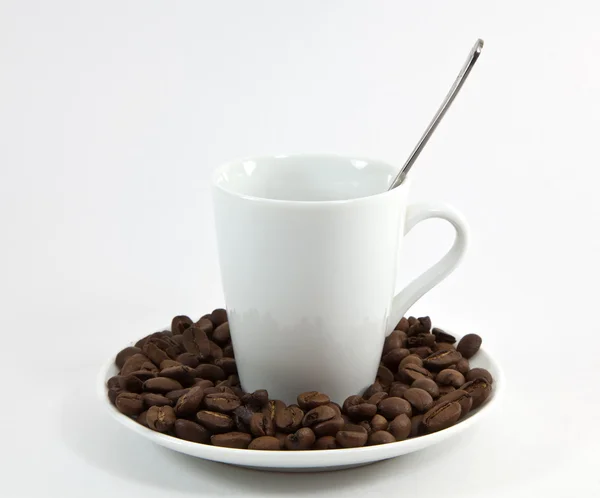 Filiżankę kawy z łyżeczką na talerzu spadają z kawy — Zdjęcie stockowe