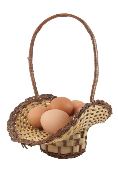 Ovos de Páscoa em cesta marrom em um fundo branco — Fotografia de Stock