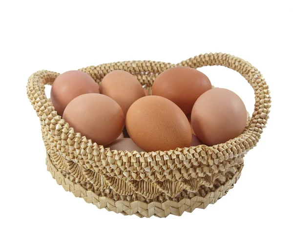 Huevos de Pascua en canasta marrón sobre fondo blanco —  Fotos de Stock