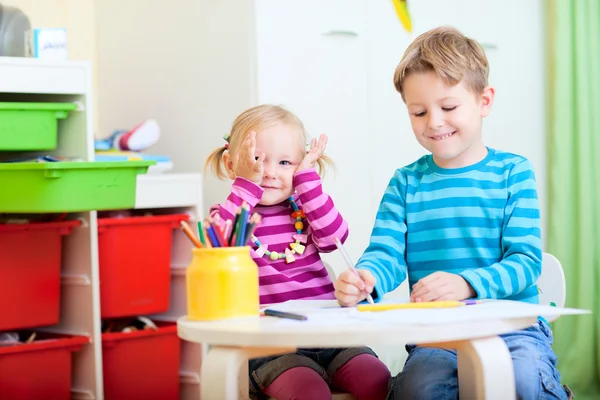 Дети сидят вместе за столом рисования — стоковое фото