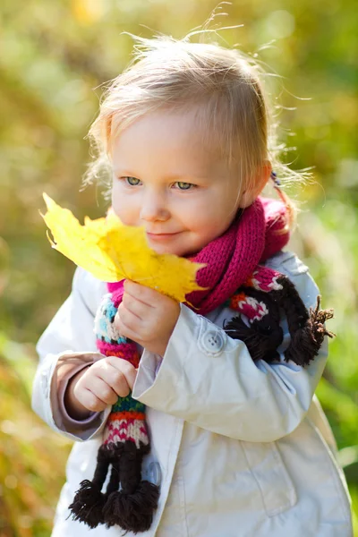 Toddler girl with yellow leaf — Stock Photo, Image