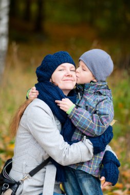 Boy kissing his mother outdoor clipart