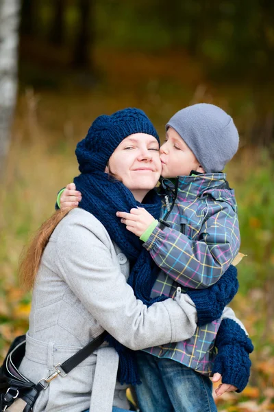 Мальчик целует свою мать на улице — стоковое фото