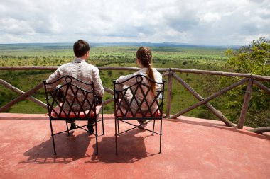 Couple on balcony of safari lodge clipart