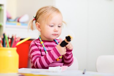 Toddler girl playing with finger puppets clipart