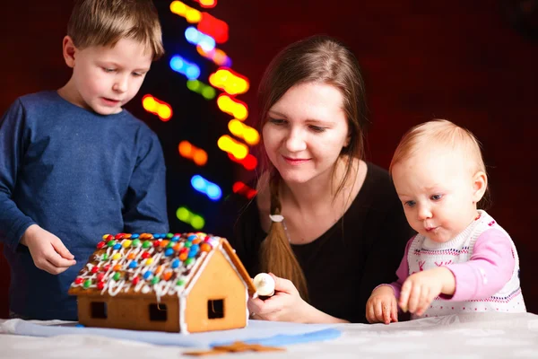 Family making gingerbread house — Stock Photo, Image
