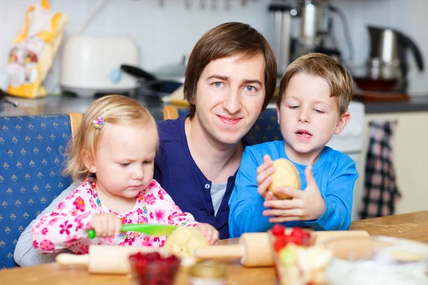 Отец с двумя детьми на кухне — стоковое фото