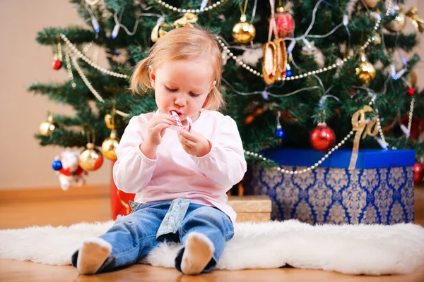 Κορίτσι μικρό παιδί με καραμέλα Χριστουγέννων — Φωτογραφία Αρχείου