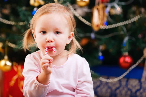 Κορίτσι μικρό παιδί με καραμέλα Χριστουγέννων — Φωτογραφία Αρχείου