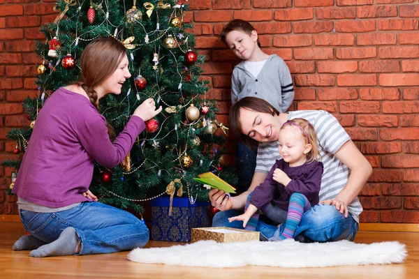 Familie schmückt Weihnachtsbaum — Stockfoto