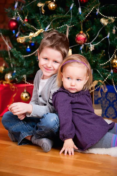Duas crianças perto da árvore de Natal — Fotografia de Stock