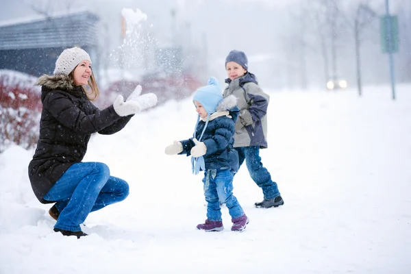 母と二人の子供が楽しんで屋外美しい冬の日 — ストック写真