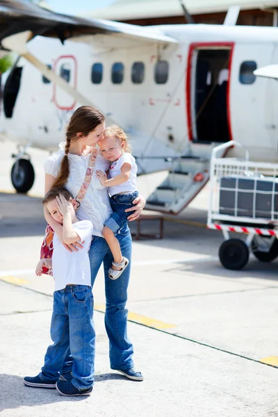 Mother and kids in front of airplane — Stock Photo, Image