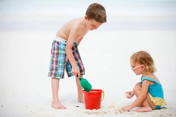 Два очаровательных ребенка играют вместе на пляже — стоковое фото