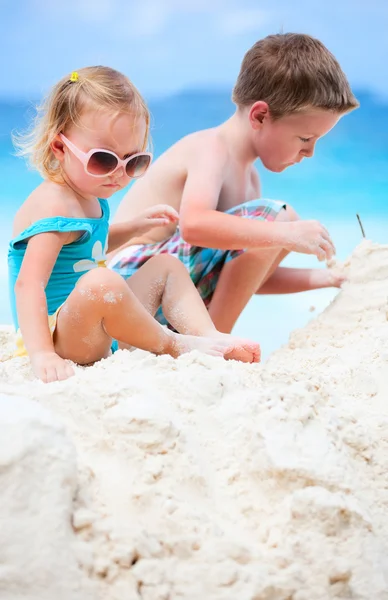 Два очаровательных ребенка играют вместе на пляже — стоковое фото