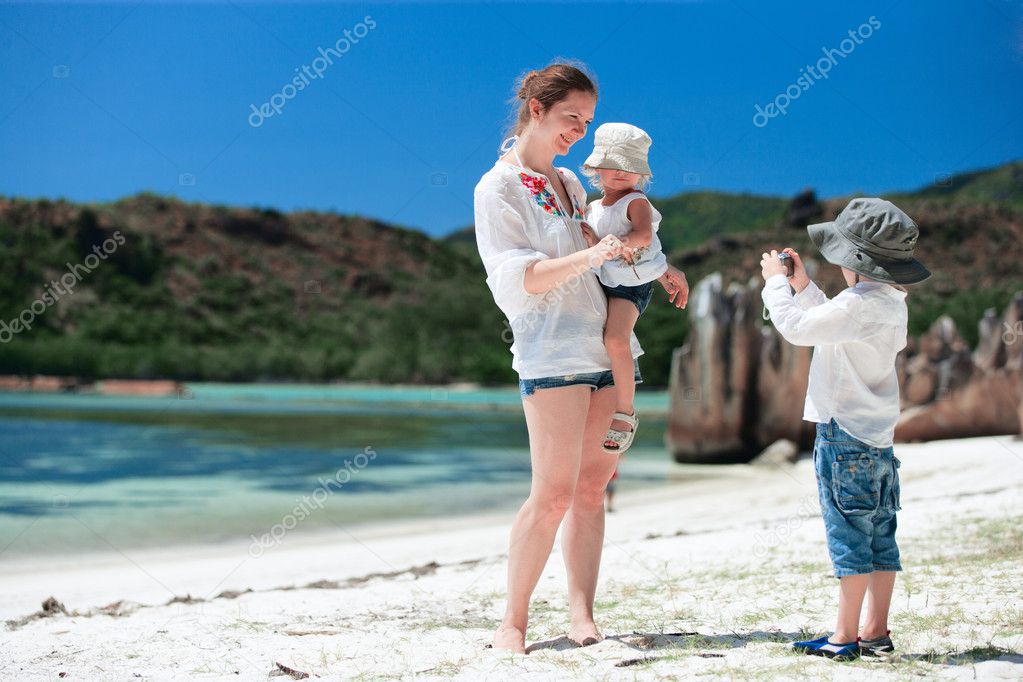 Mother holding crab while her son making photo