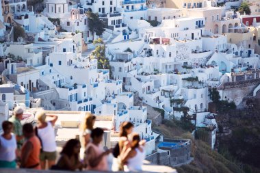 Tourist Destination. Fira main village of greek island Santorini. Tourists blurred unrecognizable. clipart