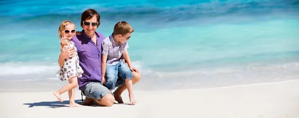 Vater mit Kindern am tropischen Strand — Stockfoto