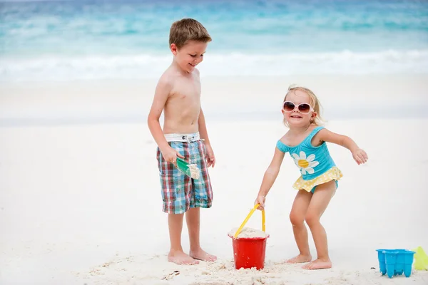 哥哥和姐姐在一起玩发送海滩 — 图库照片