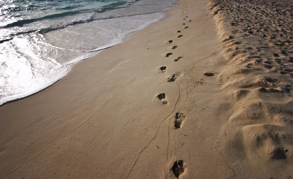 日出海岸上留下的脚印的路径 — 图库照片