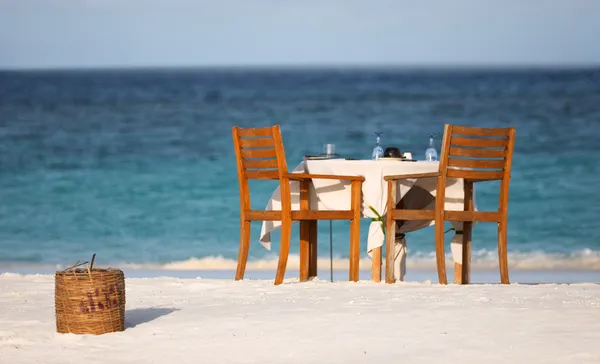 つの白い砂浜のビーチ近くの海のために準備のダイニング テーブル — ストック写真