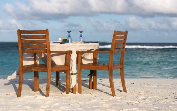 准备两个在靠近海边的白色沙滩上餐桌 — 图库照片