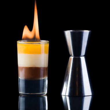 B-52 Shot and measure glass over black background. Short drink to serve at the evening. Ingredients: 1/4 measure coffee liqueur, 1/4 measure Irish Cream, 1/4 me clipart