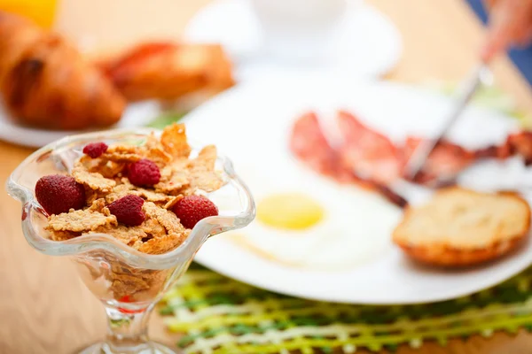 美味的早餐 玉米片与浆果 煎的鸡蛋 烤面包 牛角面包 果汁和新鲜咖啡 — 图库照片