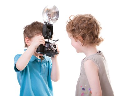 Young Photographer. Two small kids playing with antique camera. clipart