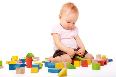 Şirin Bebek kız, renkli tahta bloklarla inşa. Beyaz arka plan üzerinde izole.